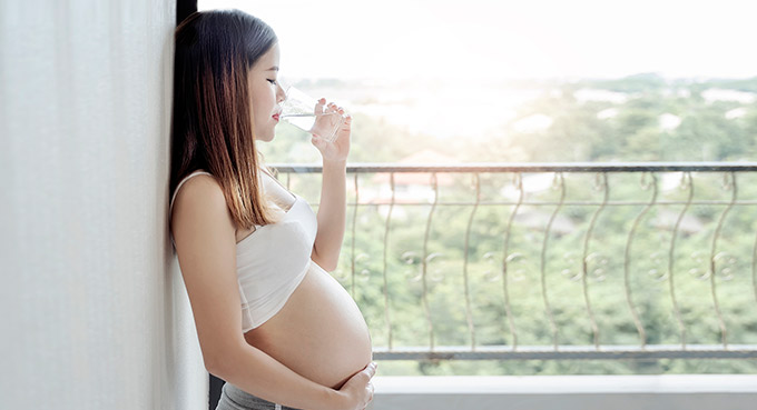 Pregnant woman drinking water.