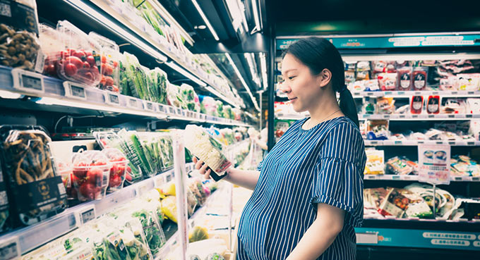 Pregnant woman 8 months shopping in supermarket