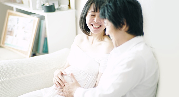 Couple touching belly hoping baby out soon