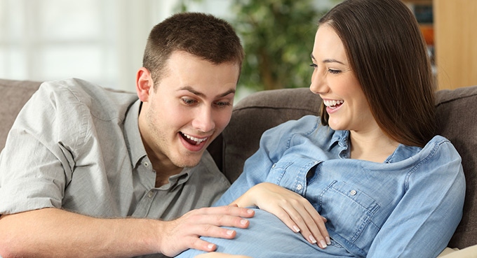 pregnant woman and her husband excited with baby’s kicking