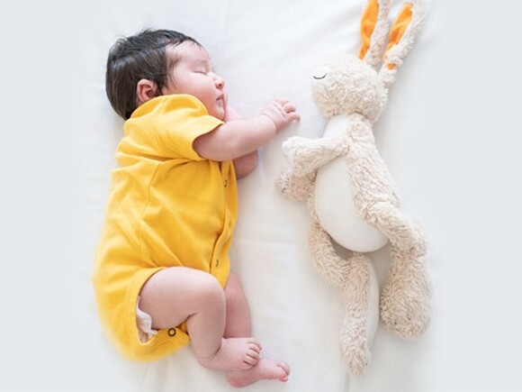 baby sleeping with stuffed toy rabbit