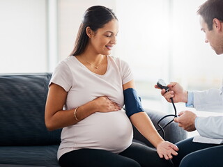 Doctor checking blood pressure of a pregnant woman.