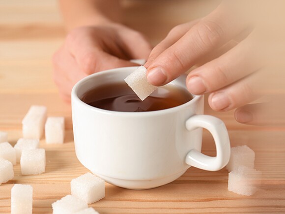 put sugar into cup of tea
